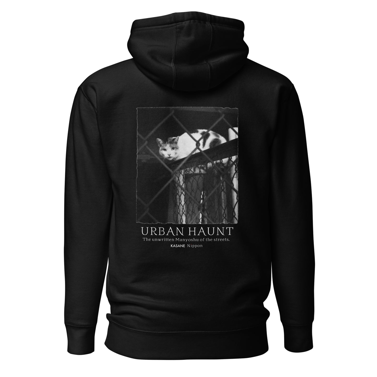Back view of black minimalist Japanese graphic hoodie featuring monochrome street cat behind chain-link fence photography.