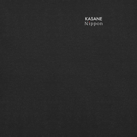 Close-up of the minimal KASANE NIPPON brand logo on the black t-shirt chest